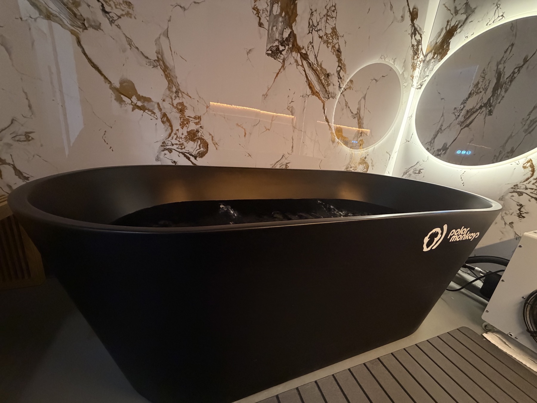Cold plunge tub filled with water in a private Sauna House suite